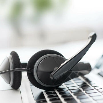 Ein Headset liegt auf der Tastatur eines Laptops