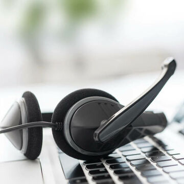 Ein Headset liegt auf der Tastatur eines Laptops