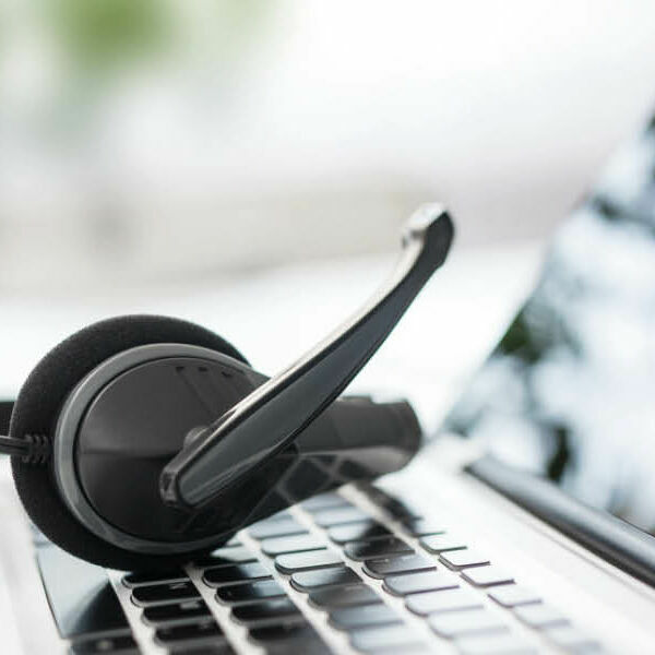 Ein Headset liegt auf der Tastatur eines Laptops